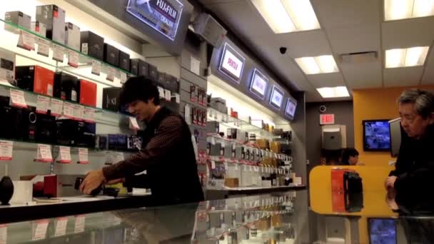 Stuff showing camera for customer inside Broadway Camera store. — Stock Video