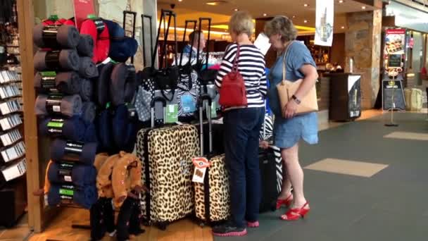 Un lado de los pasajeros dentro de la tienda de regalos para comprar equipaje en el aeropuerto YVR — Vídeo de stock