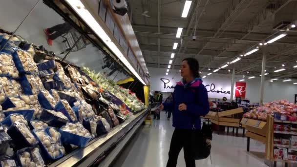 Frau sucht Pilz in Lebensmittelabteilung im Supermarkt aus. — Stockvideo