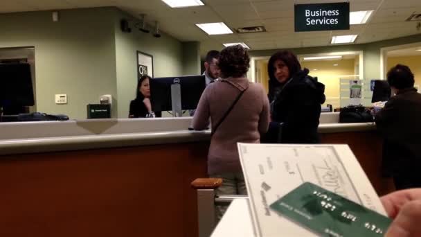 Mulher segurando um cheque dentro do banco TD — Vídeo de Stock