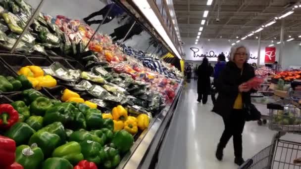 Woman selecting color peppers in produce department inside superstore. — Stock Video