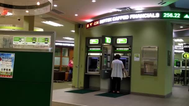 Mujer retirar dinero en el cajero automático dentro del banco TD . — Vídeos de Stock