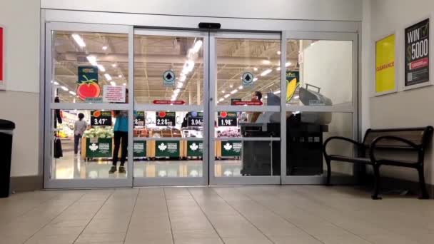 Shopper idąc przez główne wejście w supermarket — Wideo stockowe