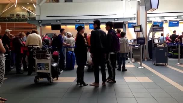 Пассажиры долго выстраиваются в очередь на стойку регистрации в аэропорту YVR — стоковое видео