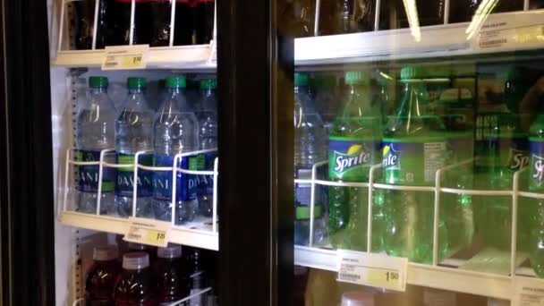 Femme prenant de l'eau de source d'une glacière au dépanneur . — Video