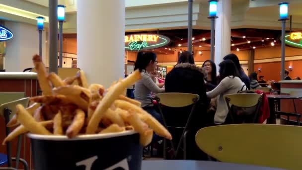 Jóvenes disfrutando de la comida moderna centro comercial patio de comidas cafetería con frituras borrosas movimiento frontal . — Vídeos de Stock