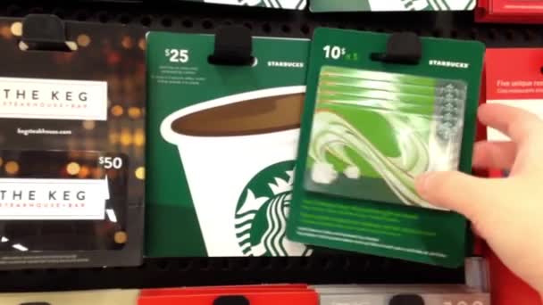 Woman picking starbucks gift card to buy in Coquitlam BC Canada. — Stock Video