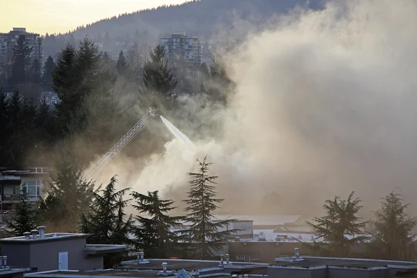 Brandweerman bemanningen vechten appartement complex brand Stockafbeelding