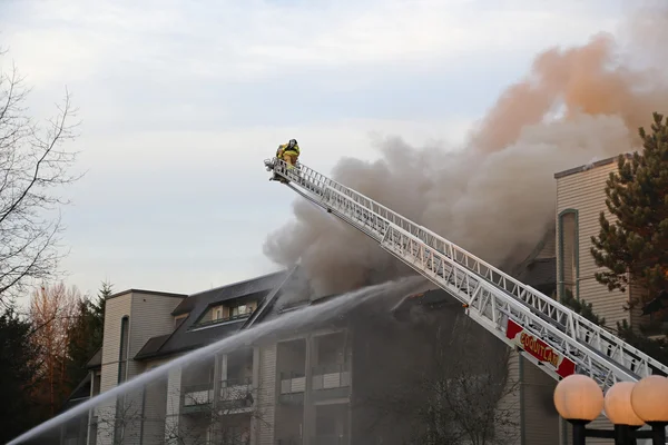 Tripulación de bomberos luchando contra incendio complejo de apartamentos Imagen de archivo
