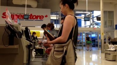 Gıda kontrol out sırasında ödeme kadının yakın Superstore içinde sayaç.