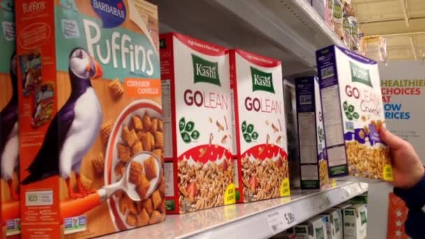 Pan shot de hombre seleccionando cereales en el departamento de comestibles dentro del supermercado — Vídeos de Stock