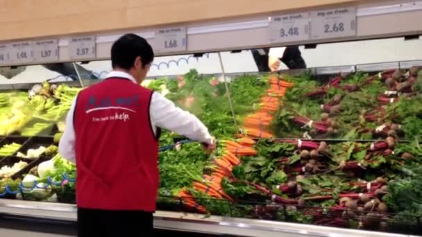 İşçi markette taze sebze için su dökerek üretmek bölümü. — Stok video