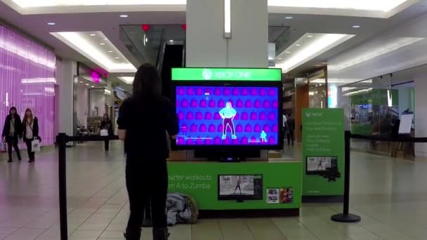 Microsoft-Mitarbeiter demonstriert mit Frau Tanzspiel in der Mall in Burnaby mit Weitwinkelaufnahme — Stockvideo