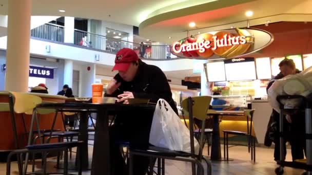 Primer plano hombre disfrutando de la comida en el patio de comidas centro comercial cafetería en Burnaby BC Canadá . — Vídeos de Stock