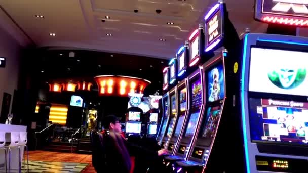 Ena sidan av personer som spelar spelautomater inuti Hard Rock Casino — Stockvideo