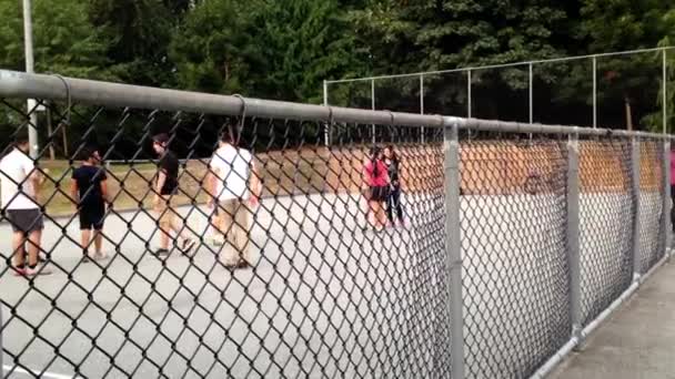 Mensen spelen basketbal op park — Stockvideo