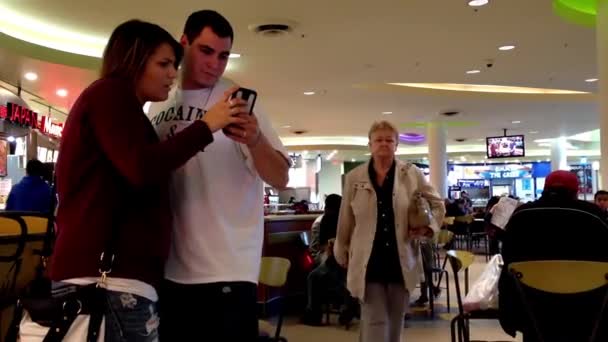 Close up coppia controllo messaggio al telefono a mensa food court . — Video Stock
