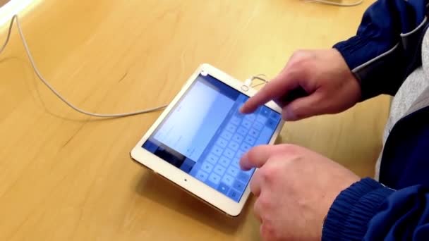 Man te typen SMS-bericht te vriend binnen Apple store — Stockvideo