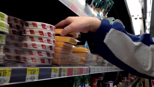 Man selecteren kaas en lezing label in supermarkt bij zuivel en forzen afdeling. — Stockvideo