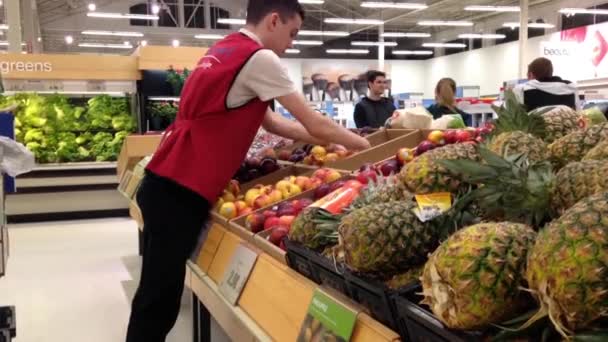 Arbeiter stellt Apfel zum Verkauf im Lebensmittelgeschäft in der Produktionsabteilung aus. — Stockvideo