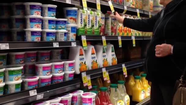 Mujer seleccionando jugo Oasis dentro del supermercado en el departamento de lácteos y forzen . — Vídeo de stock