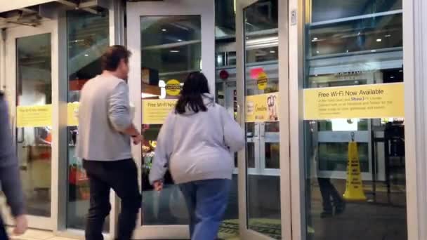 Gente caminando a través de las puertas de entrada al centro comercial — Vídeos de Stock