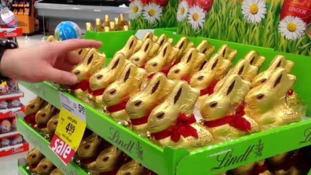 Homem comprando coelho de Páscoa de chocolate dentro do supermercado — Vídeo de Stock