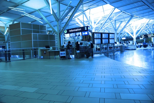 La gente que pide alguna información insdie el aeropuerto de YVR con tonos azules —  Fotos de Stock