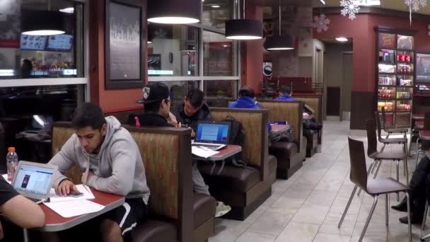 Group of friends sitting at table enjoying meal in Tim hortons with wide angle shot. — Stock Video