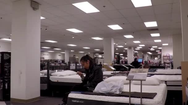 Tutup wanita membaca pesan telepon genggam di tempat tidur tampilan di dalam toko Teluk — Stok Video
