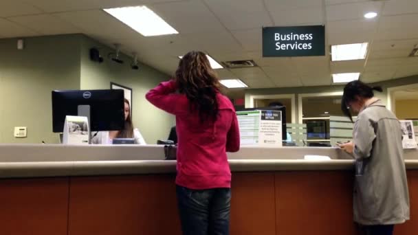 Les gens au comptoir des services aux entreprises parlent au caissier de la Banque TD . — Video