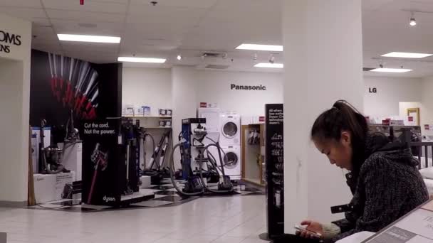 Close up woman reading mobile phone message on the display bed inside the Bay store — Stock Video