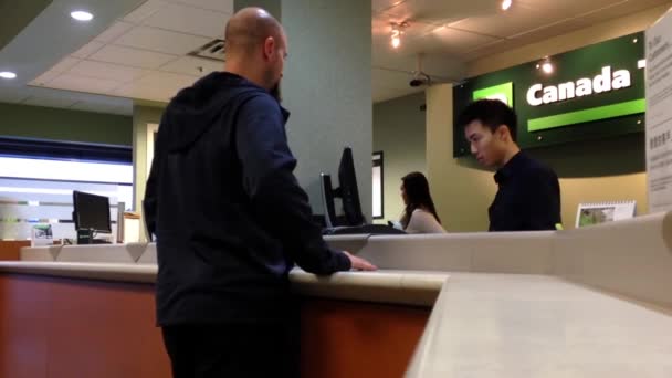 Människor på business service counter pratar med teller inuti Td Bank. — Stockvideo