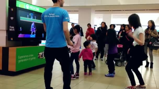 Microsoft staff demonstrates with people dance inside shopping mall — Stock Video