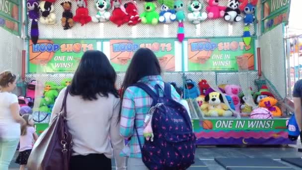 Juego de disparos de baloncesto para ganar muñecas de animales en el Carnaval de Diversiones de la Costa Oeste — Vídeo de stock