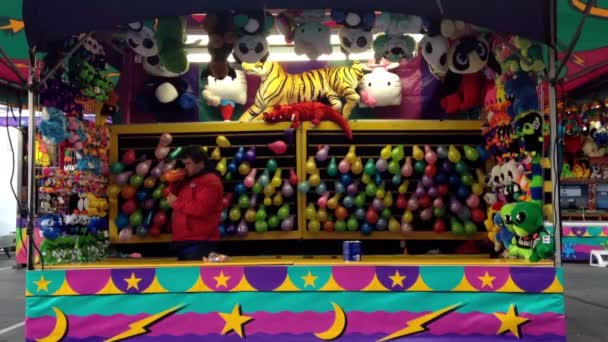 Ena sidan av dart kasta på ballonger i carnival spel — Stockvideo