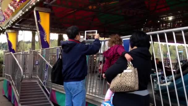 Father taking picture for family playing bumper cars. — Stock Video