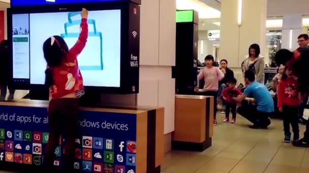 Close up young girl painting on screen game inside shopping mall — Stock Video