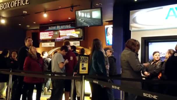 Люди выстраиваются в очередь за билетом в кино — стоковое видео