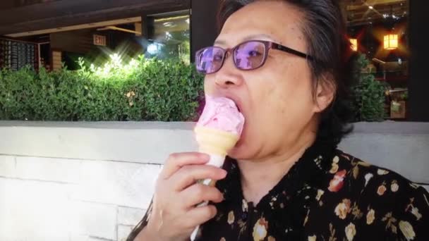 Felice vecchia donna mangiare gelato alla fragola al parco — Video Stock