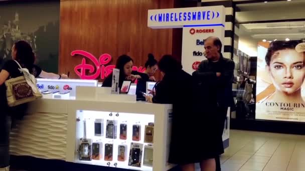 Mensen vragen cellphone verkoopbediende over cellphone plan binnen de shopping mall. — Stockvideo