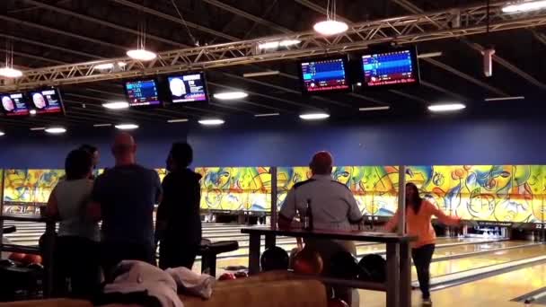 Mensen spelen bowling in de spelen hall — Stockvideo