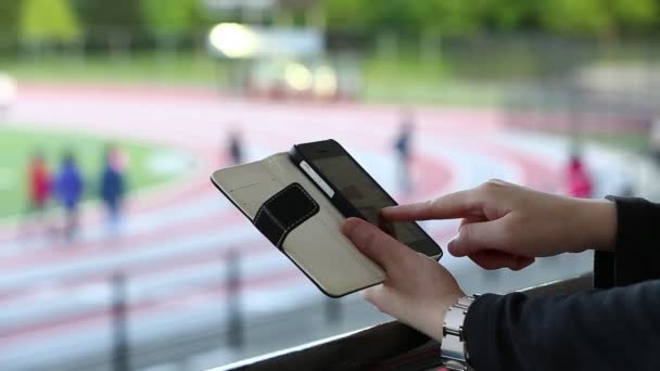 Ver foto con gesto de mano en el teléfono móvil en el parque — Vídeos de Stock