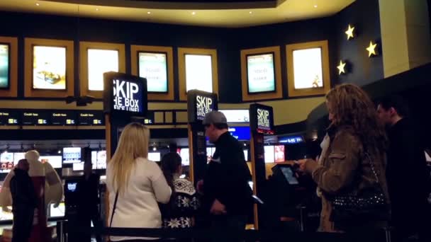 As pessoas fazem fila para comprar bilhetes de cinema no cinema — Vídeo de Stock