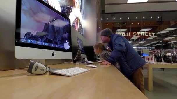 Отец и дочь играют в новый макбук в магазине Apple — стоковое видео