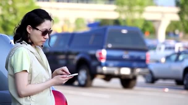 Mujer leyendo mensaje de teléfono móvil en el estacionamiento — Vídeo de stock