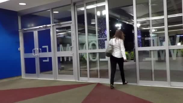 Дверь входа в торговый центр автоматически открывается при прохождении через — стоковое видео