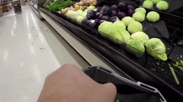 Mann trägt Korb, um Lebensmittel im Supermarkt mit Weitwinkelschuss zu kaufen. — Stockvideo