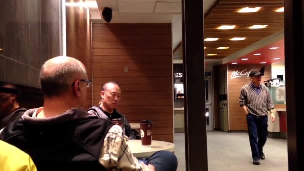 Två gamla män dricker kaffe på mcdonalds snabbmatsrestaurang — Stockvideo