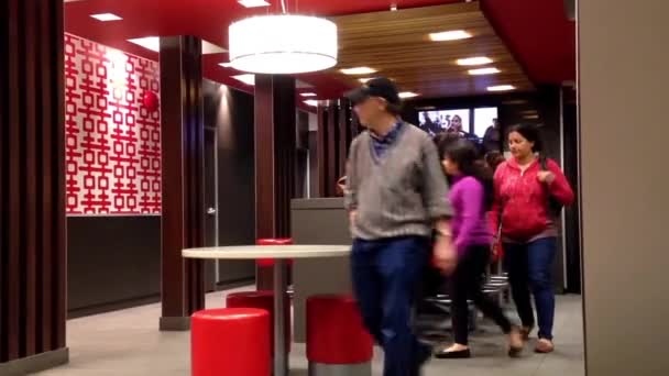 Emberek, étkezés, és nézi a Tv-on mcdonalds gyorsétterem — Stock videók